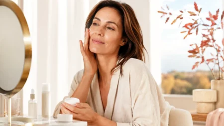 Come cambiare la skincare a settembre, cosa tenere dell’estate e cosa aggiungere per l’autunno Skincare di settembre con donna che applica la crema viso